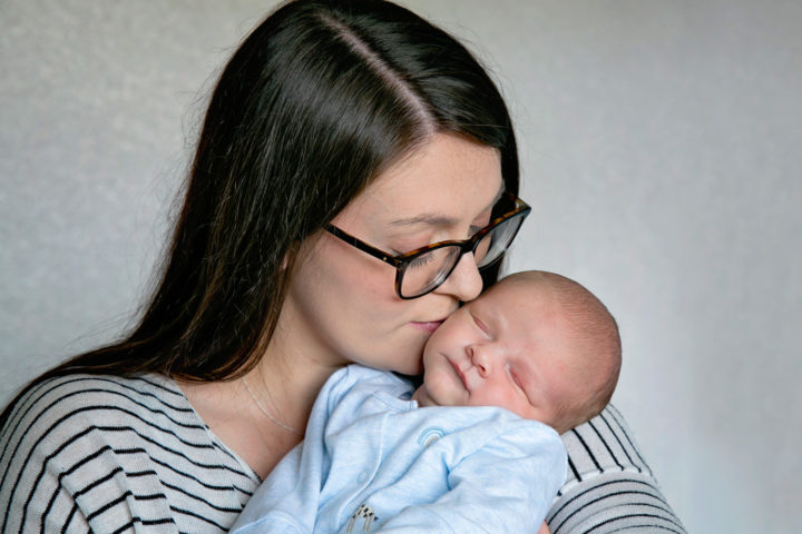 A new mummy kissing her baby on the cheek